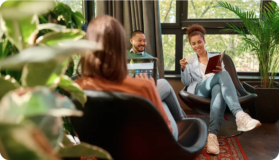 there are two people sitting in chairs in a room with a book