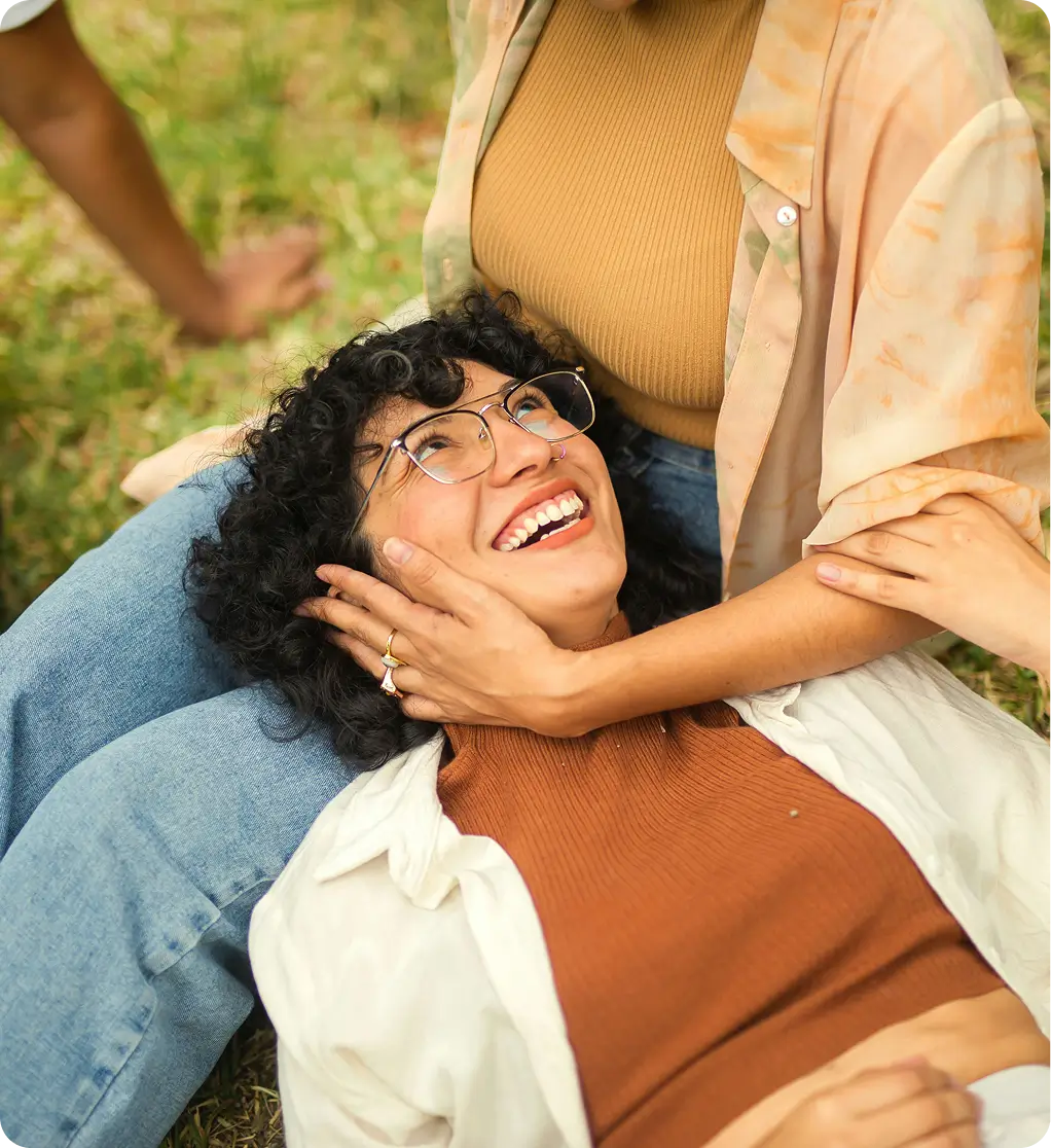there is a woman laying on the ground with her arm around a woman
