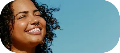 Confident woman embracing wellness under clear sky at Willow Behavioral Health, Madison, WI.