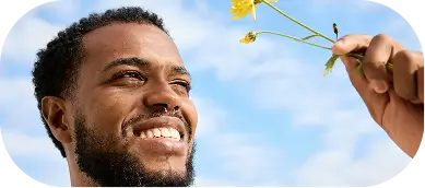 Man joyfully holding flowers, symbolizing healing and peace at Willow Behavioral Health Madison PTSD treatment.