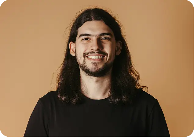 Compassionate behavioral health expert smiling warmly against a neutral background.