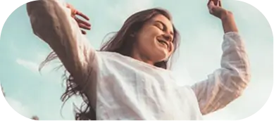 Woman joyfully embracing freedom beneath a clear sky, symbolizing exploration beyond familiar boundaries.