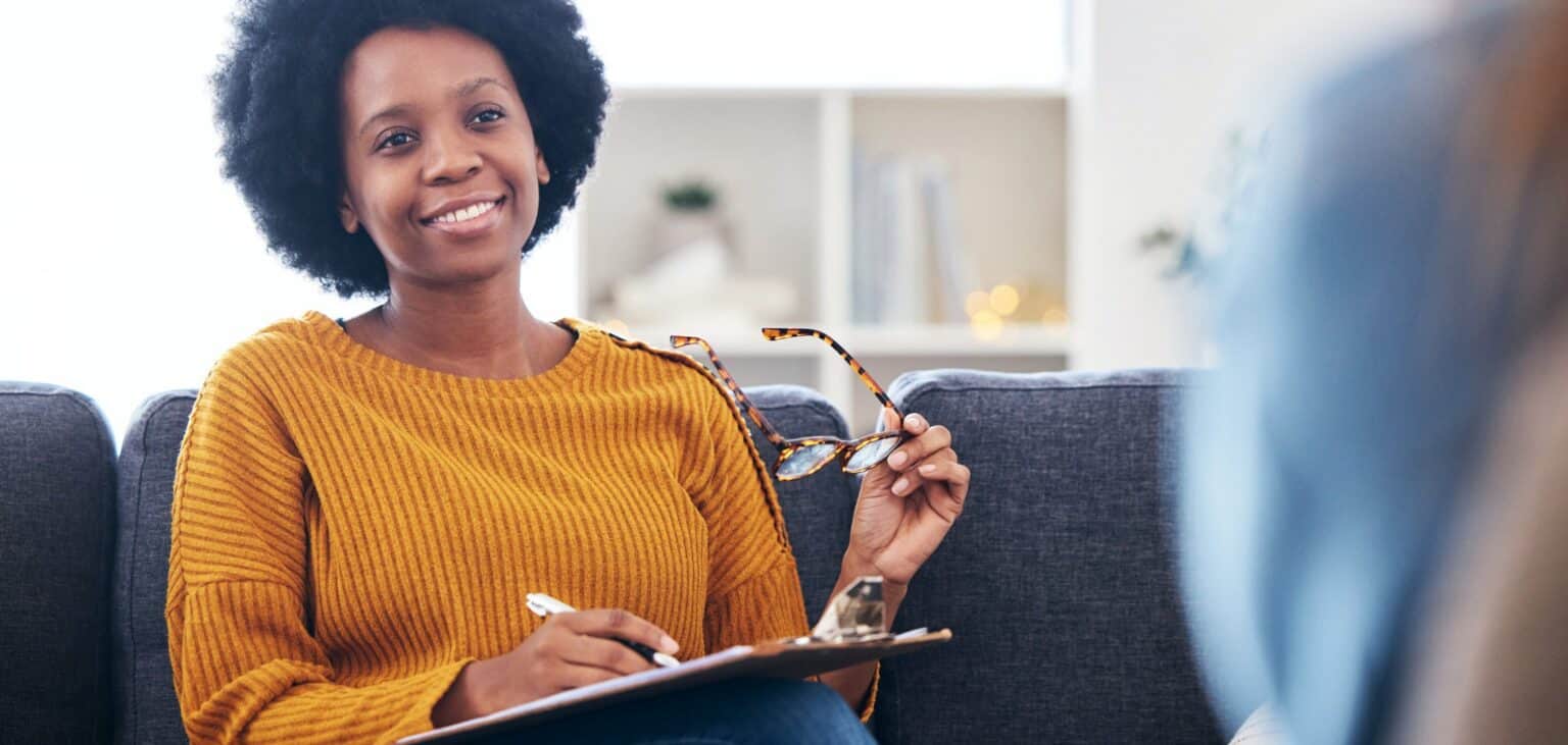 Therapist writing notes while meeting with a client for addiction therapy in Madison, WI.