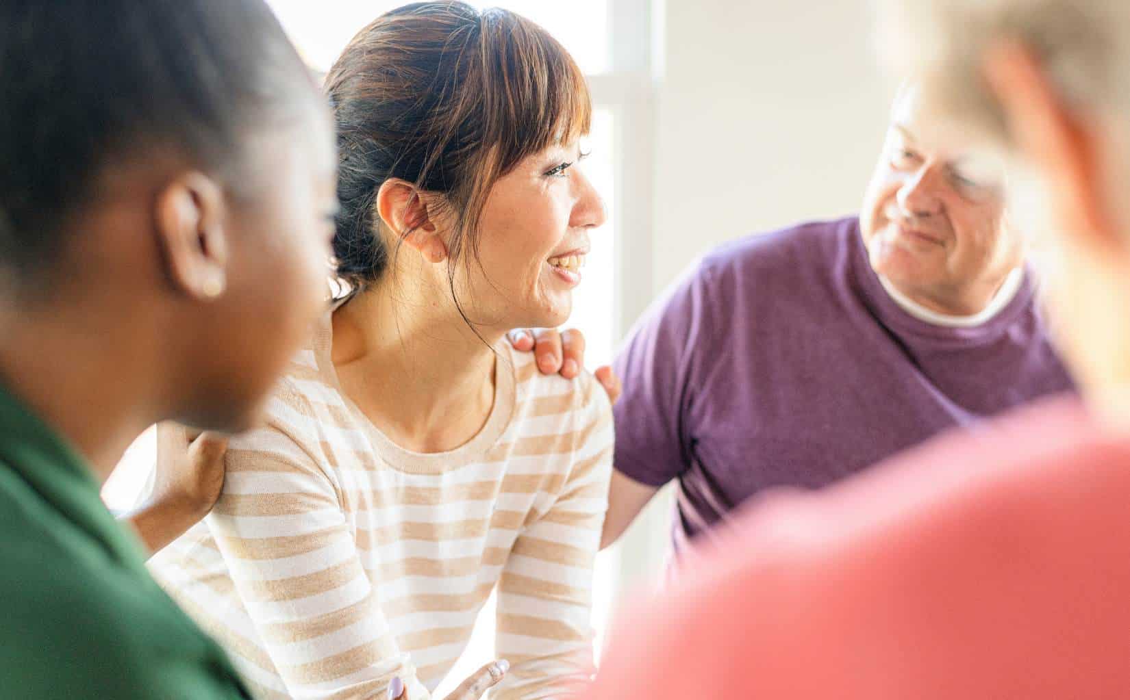 Smiling woman connecting with others during cocaine addiction treatment in Madison, WI.