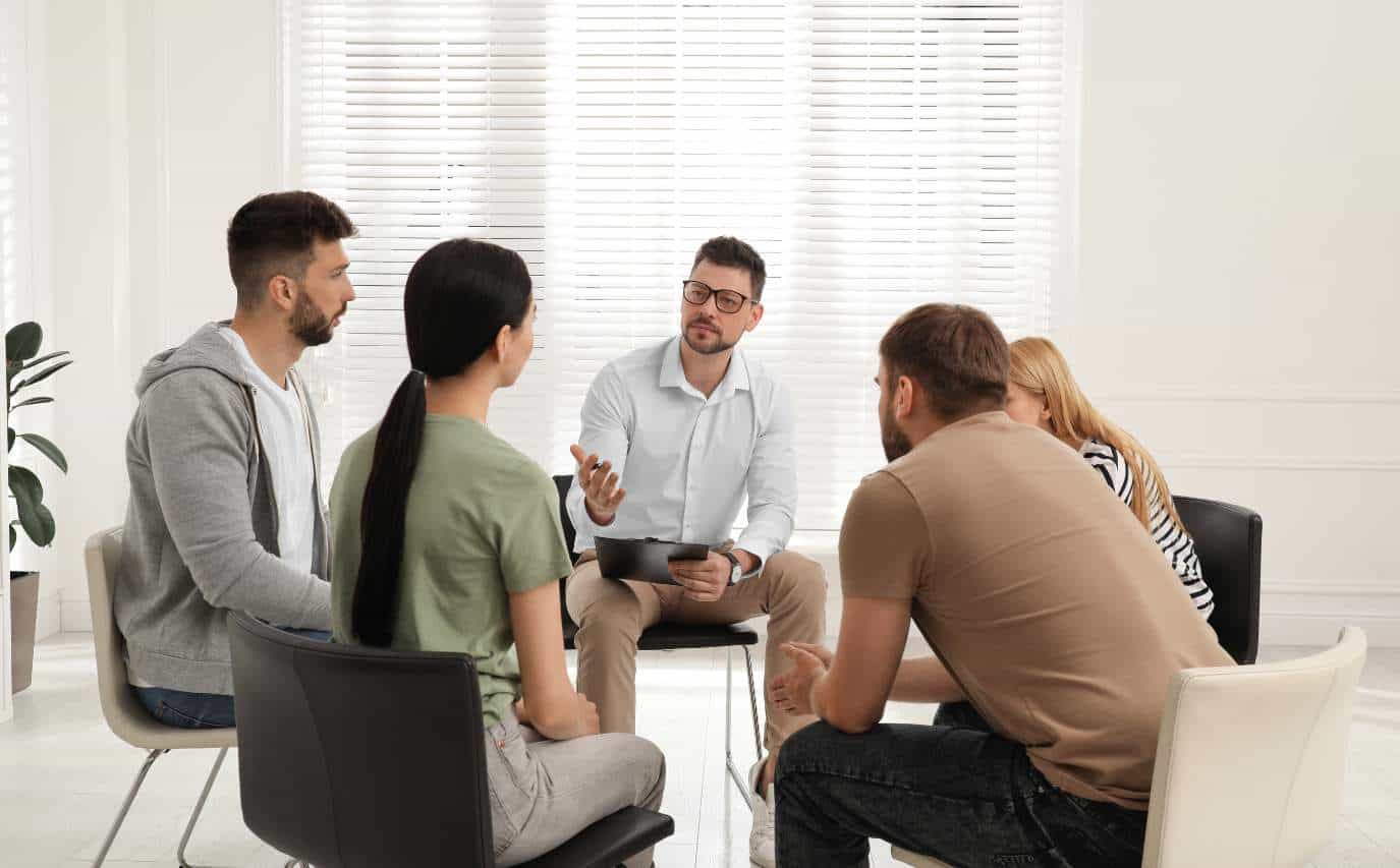 Therapist leading a group session for heroin addiction treatment in Madison, WI.