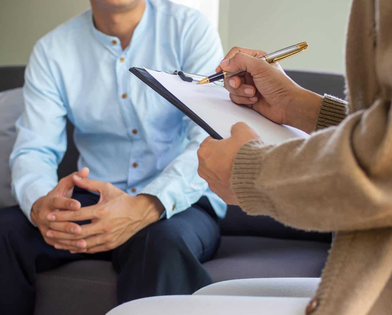 Therapist writing notes while meeting with a client during marijuana addiction treatment in Madison, WI.