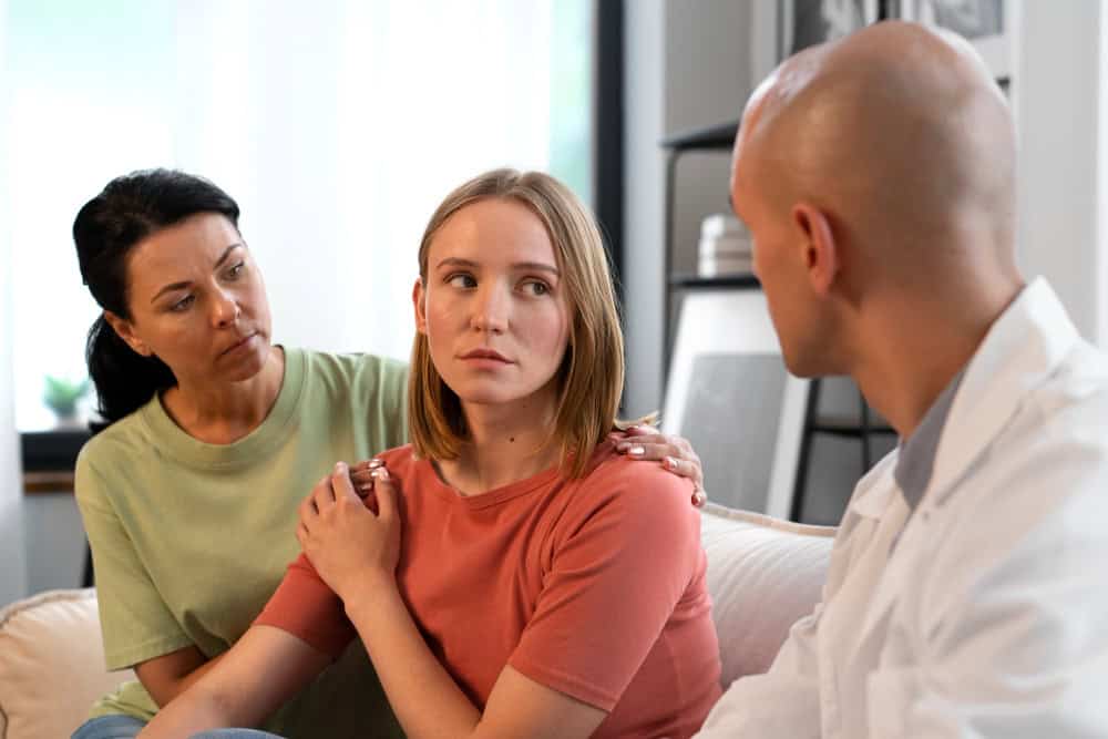 Woman speaking with a healthcare professional and receiving support from a friend during bipolar treatment in Madison.