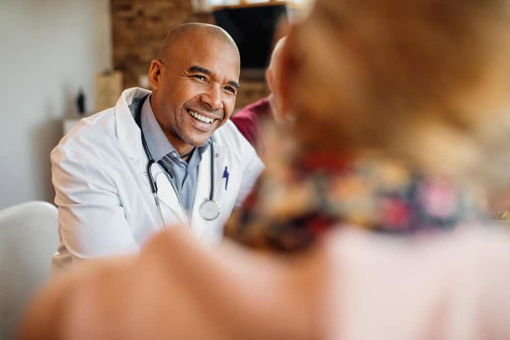 Doctor smiling during a home visit as part of prescription drug addiction treatment in Madison, WI through Willow Behavioral Health.