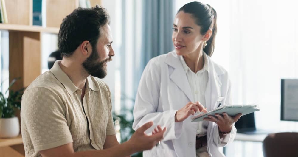 Doctor reviewing treatment information on a tablet with a patient during prescription drug addiction treatment in Madison, WI at Willow Behavioral Health.